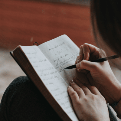 Person writing in notebook Photo by Marcos Paulo Prado on Unsplash