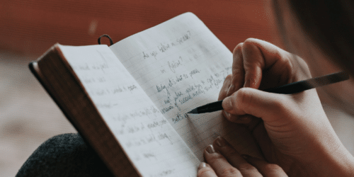 Person writing in notebook Photo by Marcos Paulo Prado on Unsplash